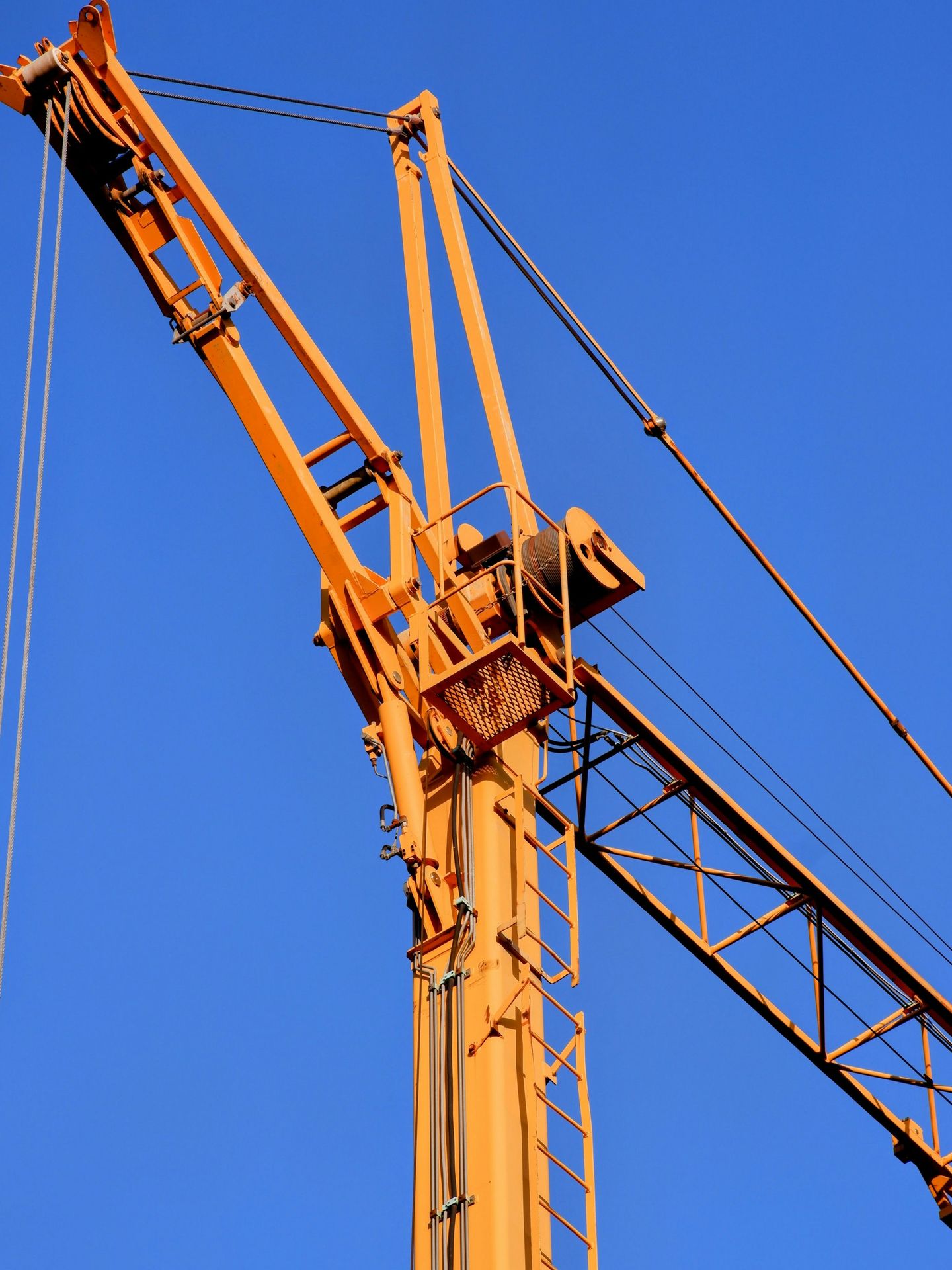 a yellow crane with a blue sky in the background